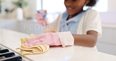 Happy girl, hands and cleaning table for housekeeping, hygiene or disinfection in chores at home. Closeup of female person, child or kid wipe surface, furniture or kitchen in bacteria or germ removal
