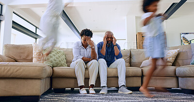 Parents, stress and headache from children in home with noise, energy or overwhelmed in living room. Hyper active, adhd and tired mother and father with burnout from kids running, games or chaos