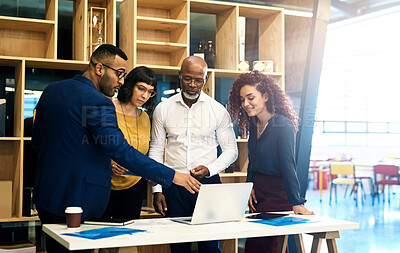 Buy stock photo Shot of a group of creative businesspeople discussing something on a laptop