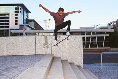 Buy stock photo Shot of a young man skating down a flight of stairs