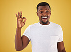 African man, ok sign and studio portrait for smile, wow and surprise for review, vote or like by yellow background. Person, hand and emoji for feedback, choice or decision with icon, symbol and happy