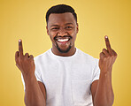 Happy, middle finger and portrait of black man in studio with rude, insulting and bad sign. Emoji, symbol and face of person with hand gesture on yellow background for joke, rebel attitude and laugh