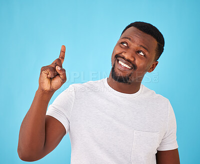 Buy stock photo African man, pointing up and studio with thinking, smile and choice with review by blue background. Person, happy and hand for sign, symbol or icon with decision, feedback and vision with ideas