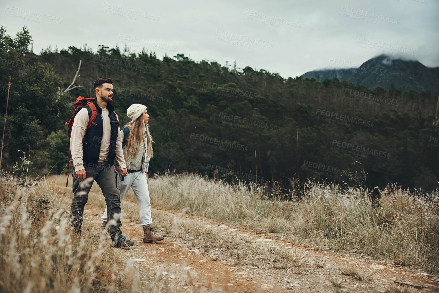 Buy stock photo Couple walking, hiking and nature with travel, mountain and backpacking with wilderness and explore outdoor. People holding hands, adventure and holiday with date, environment and trekking path