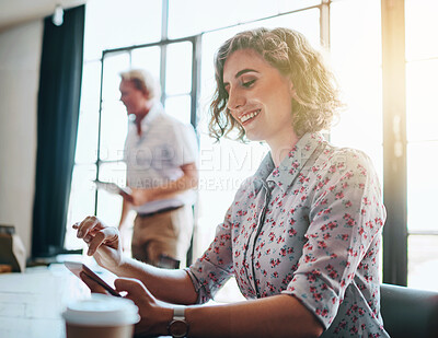 Buy stock photo Shot of a cheerful businesswoman working on her laptop while being seated in the office
