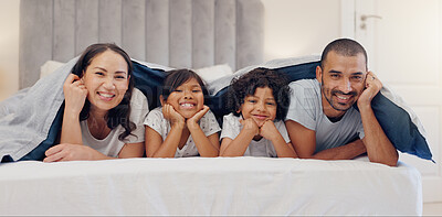 Buy stock photo Portrait, smile and children with parents in bed relaxing and bonding together at family home. Happy, fun and young mother and father laying and resting with kids in bedroom of modern house.
