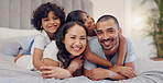 Portrait, smile and kids with parents in bed relaxing and bonding together at family home. Happy, fun and young mother and father laying and resting with children in bedroom of modern house.