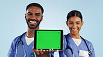 Doctor, portrait and tablet with green screen for healthcare advertising against a blue studio background. Man and woman, nurse or medical team showing technology display, chromakey or mockup space