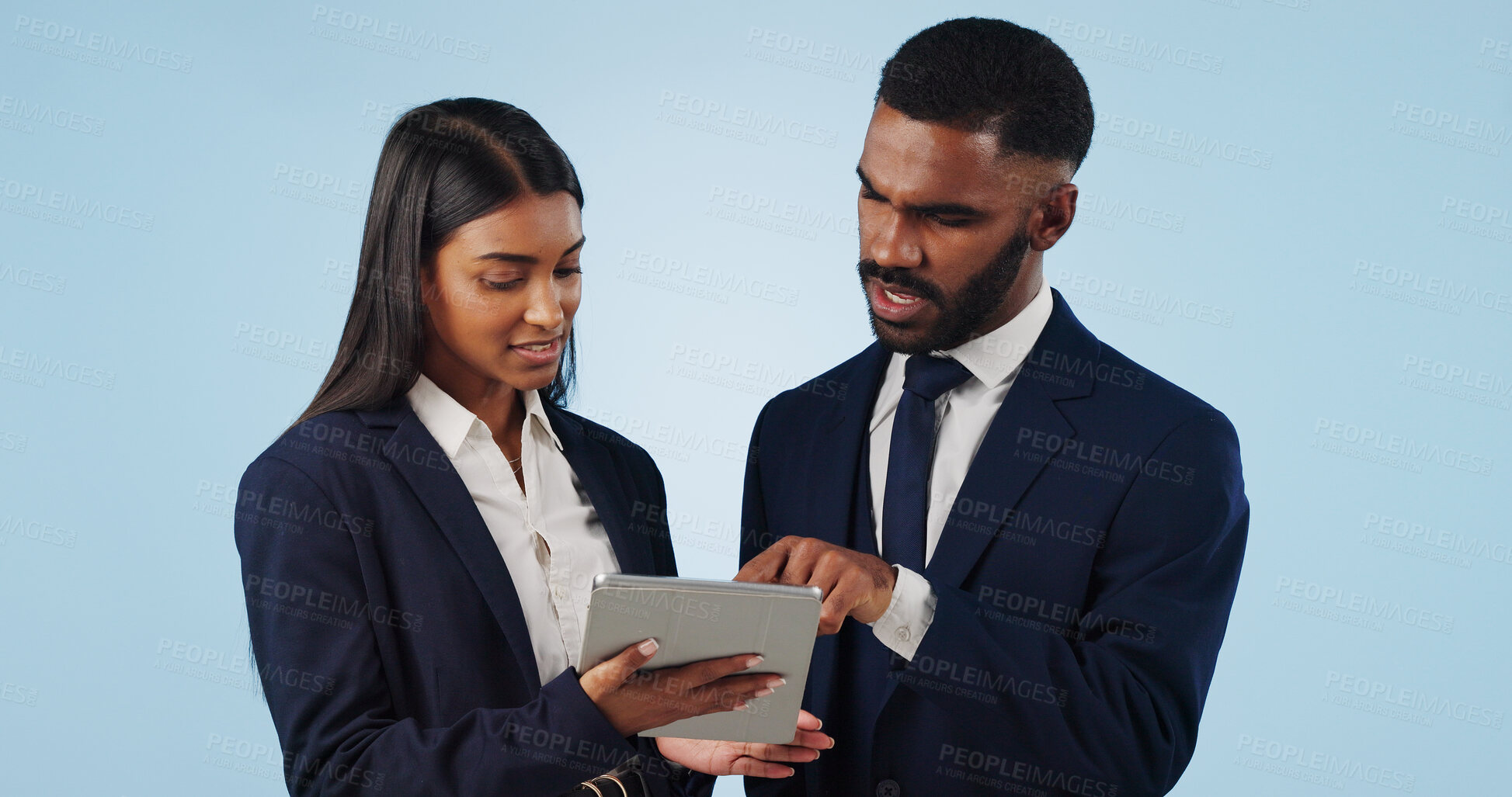 Buy stock photo Collaboration, tablet and a corporate business team in studio on a blue background for problem solving. Technology, data or feedback with a professional man and woman talking about information