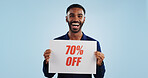 Happy man, portrait and sale sign for advertising, deal or discount against a blue studio background. Excited male person showing billboard or poster for marketing, promotion or special on mockup