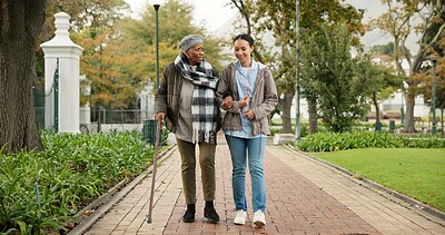 Help, cane and nurse with old woman in park for relax, support and person with a disability. Elderly care, conversation and healthcare with caregiver and patient in nature for medical rehabilitation