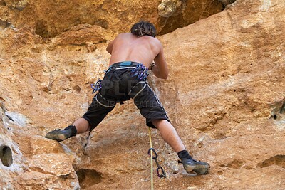 Buy stock photo Rearview of rugged bare chested rock climber climbing a rockface