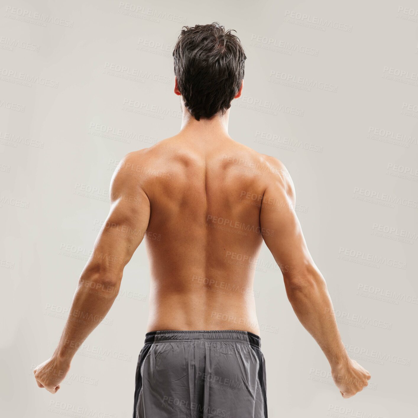 Buy stock photo Rearview of a shirtless man stretching his back before a workout