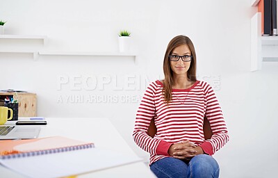 Buy stock photo Portrait of a young woman sitting at a desk