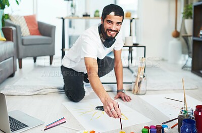 Buy stock photo Shot of a young man painting while sitting on the floor at home