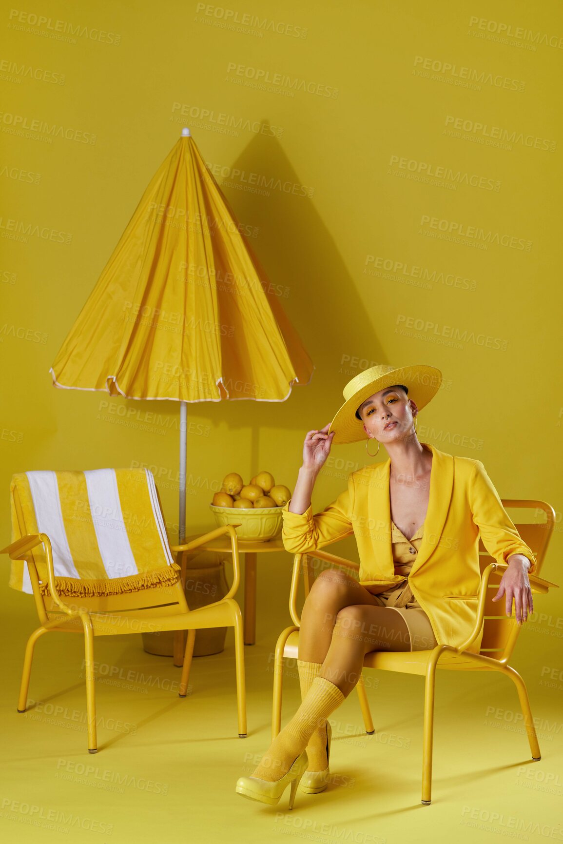 Buy stock photo Studio portrait of a young woman dressed in stylish yellow clothes against a yellow background