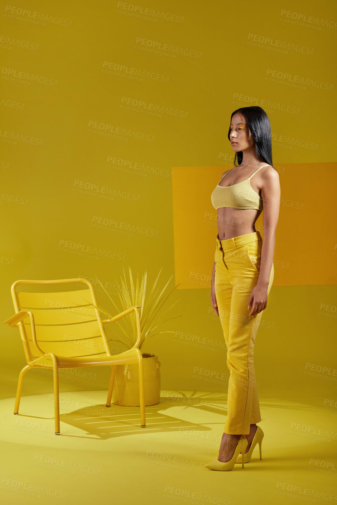 Buy stock photo Studio shot of a young woman dressed in stylish yellow clothes against a yellow background