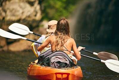 Buy stock photo Women friends rowing a kayak or boat on a river or lake while on summer vacation or travel. Tourist explore nature on water during a tropical adventure kayaking in the a wildlife wilderness forest 