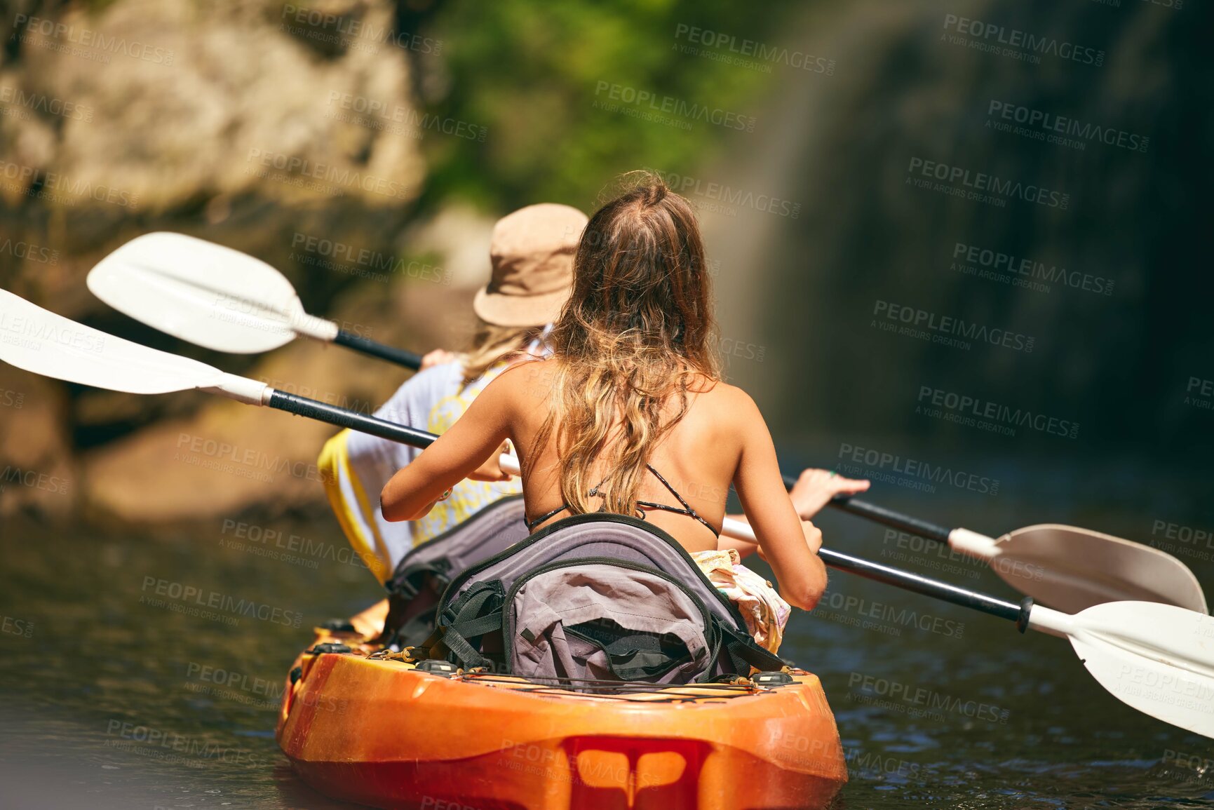 Buy stock photo Women friends rowing a kayak or boat on a river or lake while on summer vacation or travel. Tourist explore nature on water during a tropical adventure kayaking in the a wildlife wilderness forest 