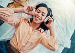 Woman with headphones, music or podcast, freedom and relax, carefree in her home, happy with technology and audio with top view. Young person, listening and streaming, radio and online subscription.