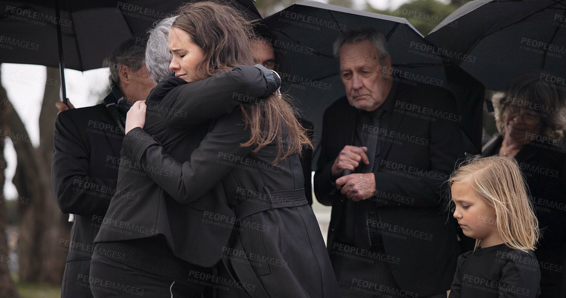 Buy stock photo Funeral, crying family and people hug for grief support, mourning depression and death at emotional burial event. Kid child, mom and group together with widow hugging senior mother at coffin ceremony