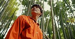 Japanese man, bamboo trees and nature on walk, adventure and hiking with thinking, ideas and journey. Person, outdoor or trekking for peace, mindfulness or woods at Fushimi Inari on vacation in Kyoto