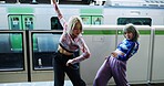 Asian woman, dancing and street performance by railway station for energy or art in underground subway. Female person, friends or hip hop dancers in Japan, practice or training together by transport