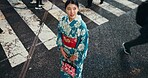 Japanese, woman in traditional dress and walk with city view and travel with journey outdoor. Fashion, adventure and urban street in Kyoto, kimono or dress for culture and style with local trip