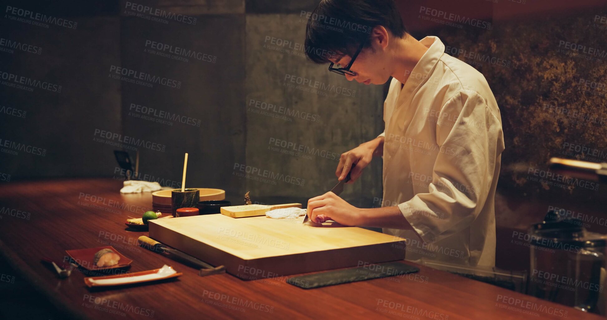 Buy stock photo Japan chef, restaurant and cutting fish for sushi, glasses and precision with knife for healthy food in kitchen. Asian man, hands and culinary artist on job by wood board, table and raw seafood menu