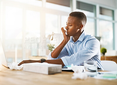 Buy stock photo Shot of a young businessman suffering with a cold while sitting at his desk at work