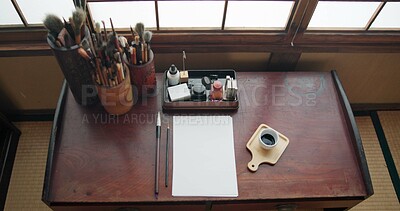 Buy stock photo Art, paint brush and painting tool for painter, calligraphy and drawing at a desk for creative work. Sketch paper, Japanese sumi and home studio with ink pot and document for creativity above