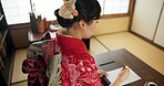 Traditional, writing and Japanese woman in home with paper, documents and script at desk. Creative, Asian culture and person with paintbrush, ink and tools for calligraphy, font and text in house