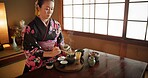 Japanese, woman and kimono for tea ceremony in Chashitsu room with matcha and traditional custom. Person, temae and vintage style outfit or dress for culture, fashion and honor with antique crockery 