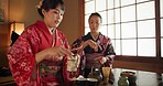 Culture, teapot and Japanese women with tea in home with traditional herbs, leaves and flavor in home. Ritual, indigenous and people with herbal beverage for ceremony, calm and wellness for drinking