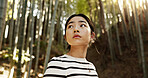 Thinking, bamboo and Japanese woman in forest for adventure on holiday, vacation and morning. Travel, nature and person with natural plants in woods for explore, walking and freedom in Kyoto outdoors