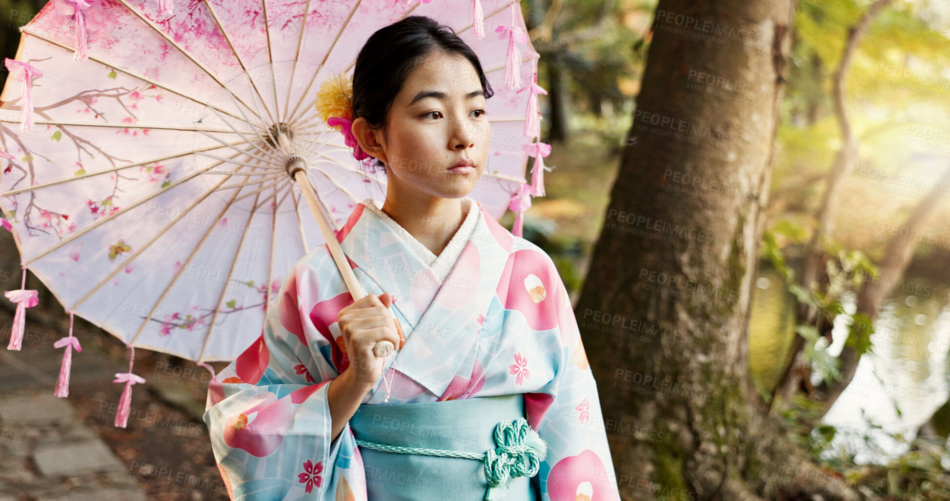 Buy stock photo Umbrella, traditional and Japanese woman in park for wellness, fresh air and thinking outdoors. Travel, culture and person in indigenous clothes, style and kimono for zen, peace and calm in nature