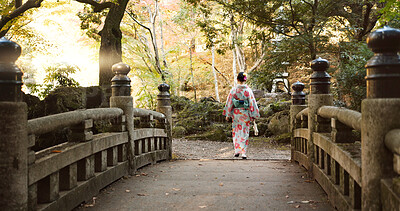 Buy stock photo Bridge, walking and Japanese woman in park for wellness, fresh air and relaxing in nature. Travel, traditional and person in indigenous clothes, fashion and kimono outdoors for zen, calm and peace