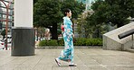 Japan, woman in a city and walking with traditional clothes, travel and fresh air with wellness, healthy and peace. Person, freedom and girl with culture, movement and thinking in a street 