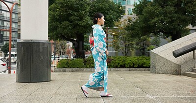 Buy stock photo Japan, woman in a city and walking with traditional clothes, travel and fresh air with wellness, healthy and peace. Person, freedom and girl with culture, movement and thinking in a street 