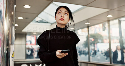 Buy stock photo Phone, subway and a Japanese woman in city on social media, networking and notification in Tokyo. Smartphone, girl and serious person on mobile communication technology, thinking and internet app
