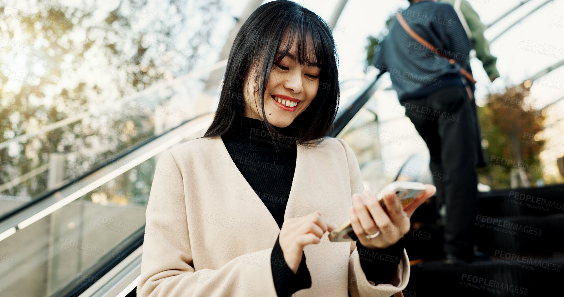 Buy stock photo Smartphone, happy and Japanese woman on escalator in city, social media app or reading email notification on internet technology in Tokyo. Phone, mobile and person smile outdoor to travel or commute