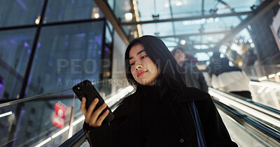 Buy stock photo Japanese, woman on escalator and smartphone, travel and commute, communication with social media and adventure. Text, email and online chat with connectivity, mall or airport with mobile app in Japan