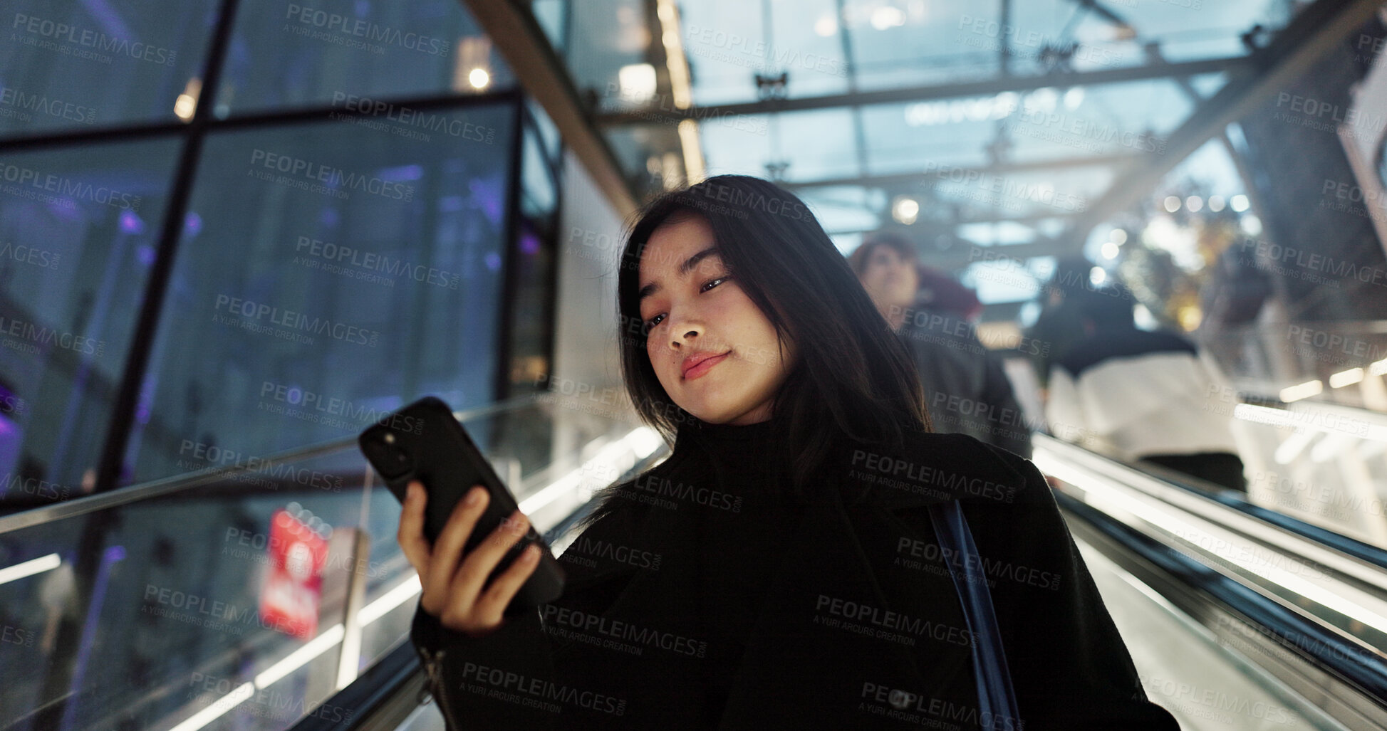 Buy stock photo Japanese, woman on escalator and smartphone, travel and commute, communication with social media and adventure. Text, email and online chat with connectivity, mall or airport with mobile app in Japan