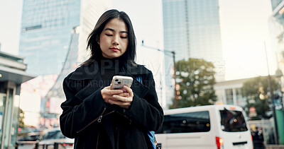 Buy stock photo Smartphone, city and Japanese woman on social media, reading email or notification in Tokyo. Phone, mobile and serious person in urban street outdoor for communication technology, network or internet