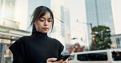 Buy stock photo Phone, city and Japanese woman on internet, reading email and notification in Tokyo. Smartphone, girl and serious person on mobile in urban town outdoor for communication, typing and social media