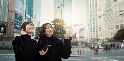 Buy stock photo Phone, friends and women pointing in city for travel, social media and connection together in Japan. Smartphone, girls and happy people in urban street outdoor to commute with digital app in Tokyo