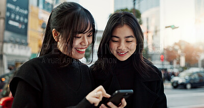 Buy stock photo Smartphone, friends and happy women in city for travel, social media and connection together in Japan. Phone, smile and girls in urban street outdoor, reading info or network on technology in Tokyo