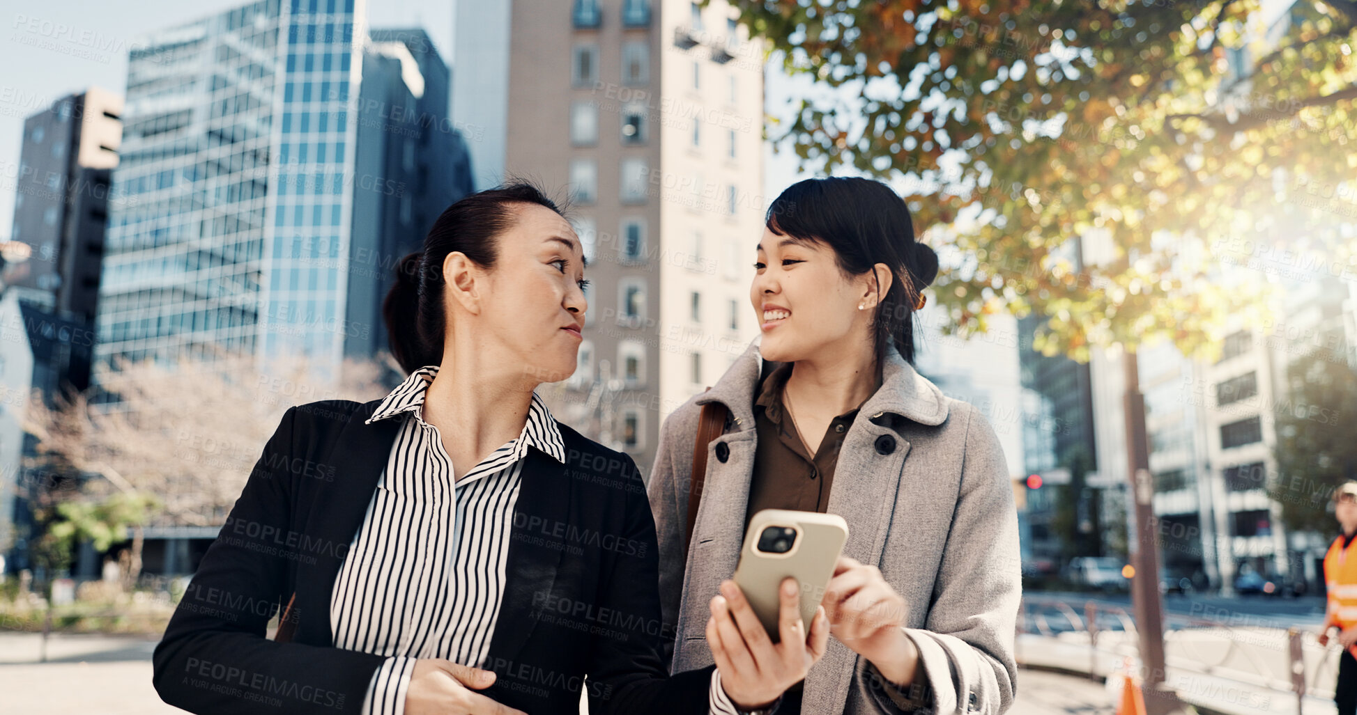 Buy stock photo Phone, smile and Japanese business woman in city together for travel, journey or commute. Collaboration, planning and discussion with happy employee team reading text message outdoor in Tokyo