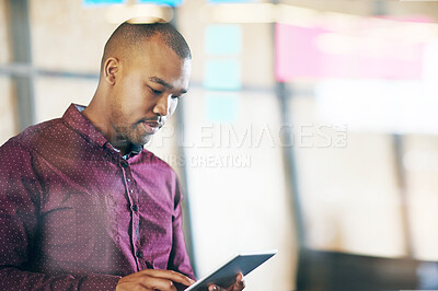 Buy stock photo Shot of a male designer using a digital tablet in the office