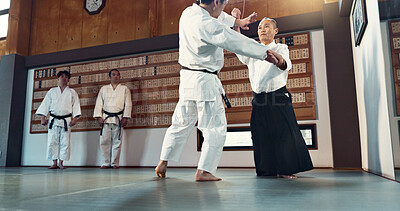 Buy stock photo Aikido, sensei and Japanese students with discipline, fitness and action in class for defence or technique. Martial arts, people or fighting with training, uniform or confidence for culture and skill